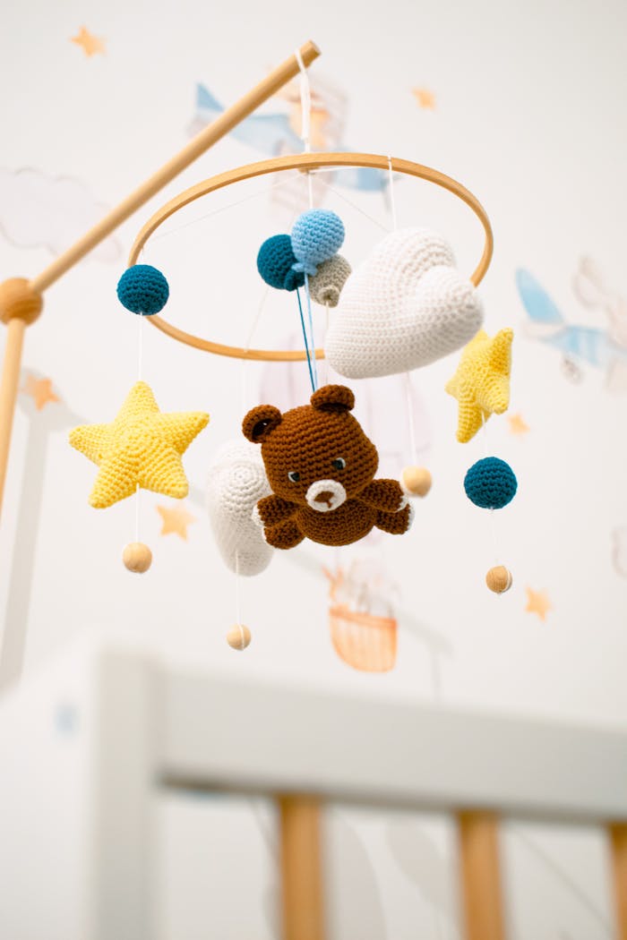 Adorable crochet teddy bear mobile with stars and clouds for baby nursery.